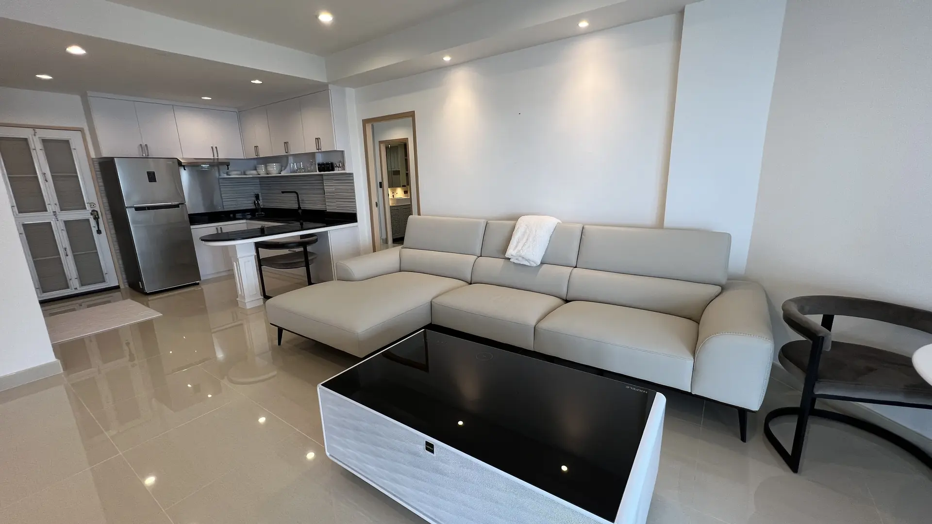 Living area with sectional sofa, kitchen and full-height doors