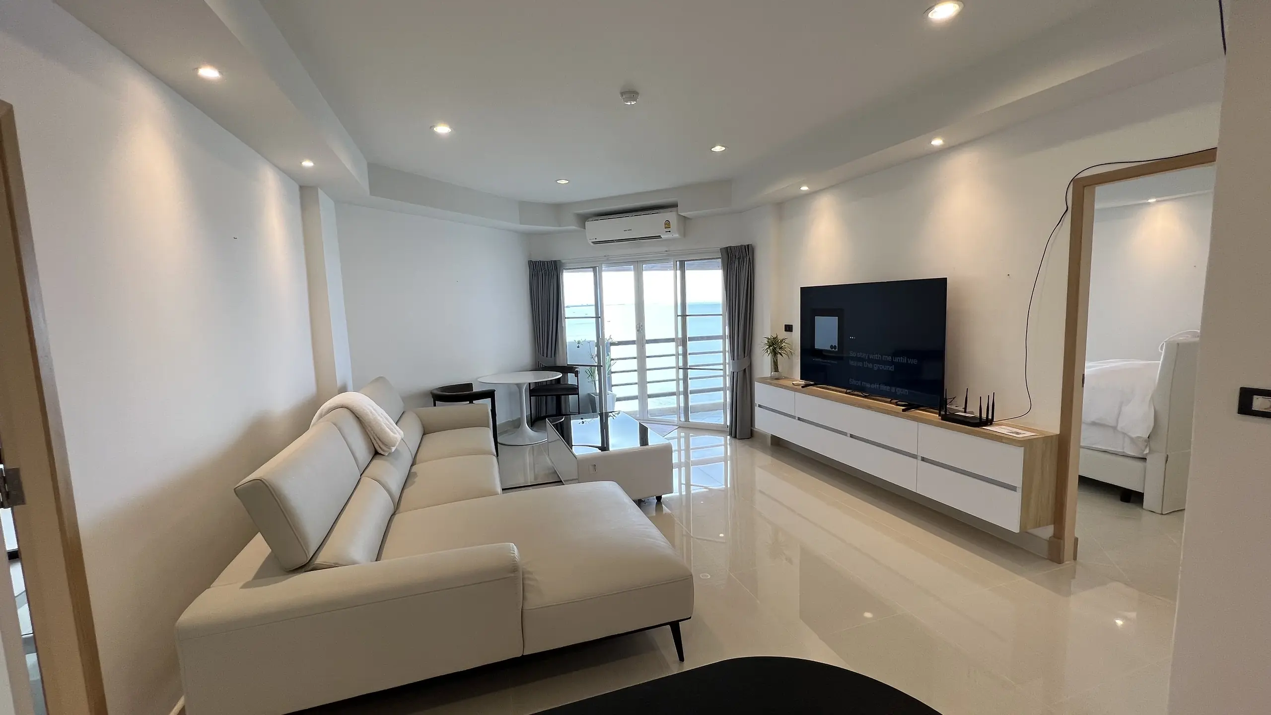 Remodeled living room with white sectional sofa and sea-facing windows